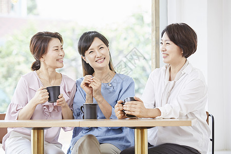 成年女子和伙伴在咖啡店享受下午茶图片