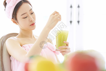 搅拌果蔬汁的年轻女子图片