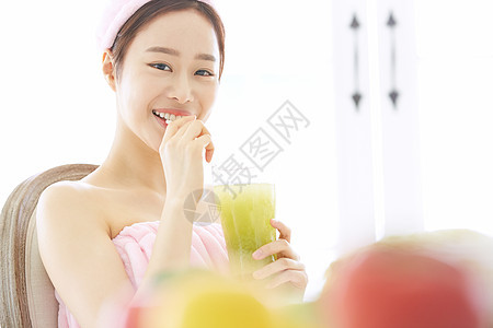 年轻女子微笑的喝蔬菜汁图片