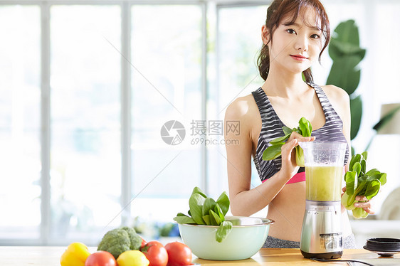 拿着蔬菜榨汁的运动少女图片