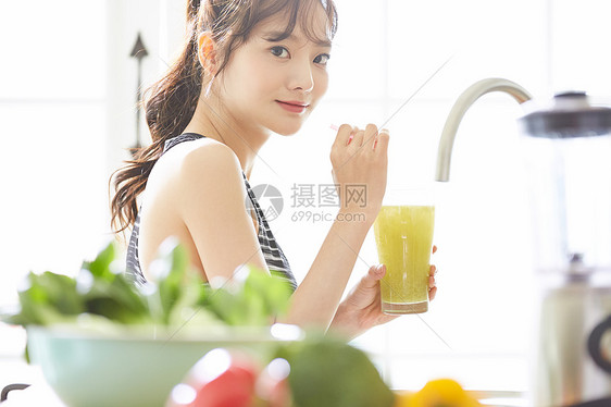 拿着蔬菜汁微笑的年轻女子图片
