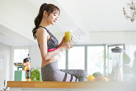 拿着健康蔬菜汁的运动女性图片