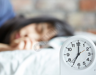 时钟早上7点早上准备起床的女生背景