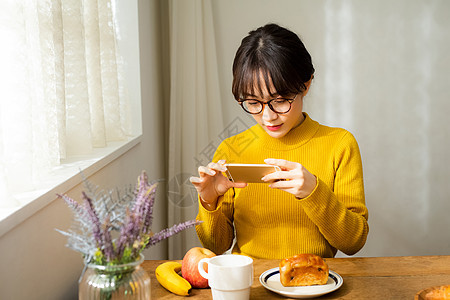 精致生活吃早餐拍照的女性图片