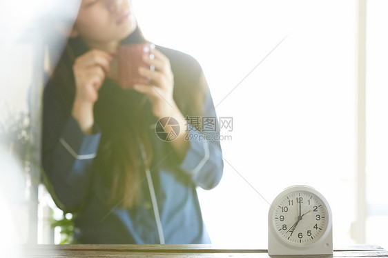 早上喝水休息的女性图片