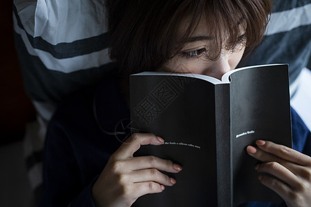 躺在床上看书的青年女图片