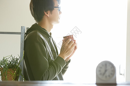 手拿水杯的居家男性图片