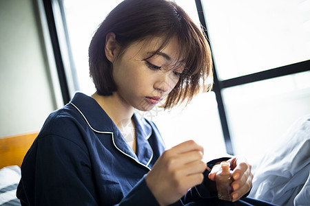 卧室床上涂指甲油的年轻女孩图片