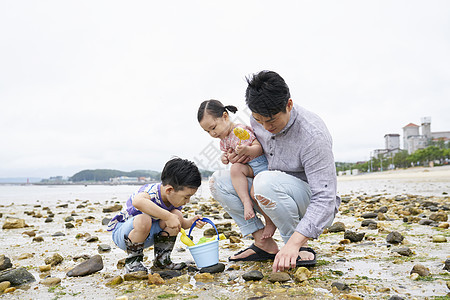 在海边捡石子的一家人图片