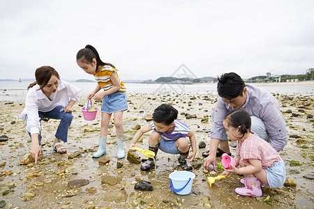 在海边捡石子的一家人图片