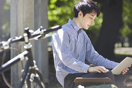 日本人笔记本坐公园电脑男图片
