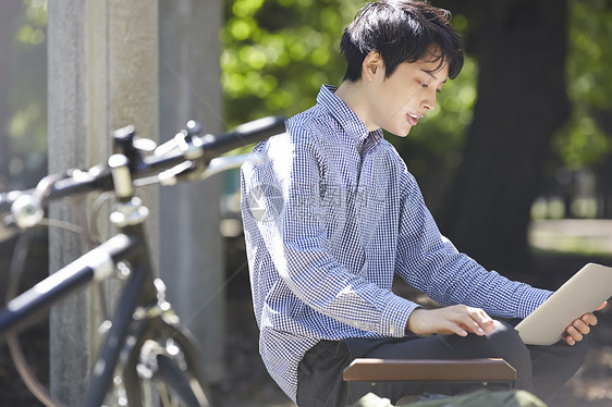 日本人笔记本坐公园电脑男图片