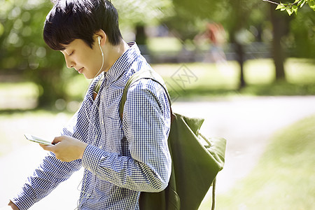 戴着耳机低头微笑的男子图片