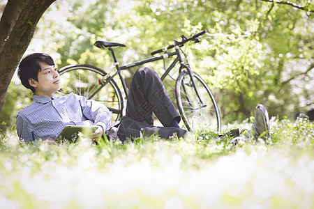 躺在草坪上休息的男青年图片
