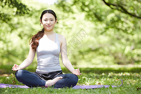 盘腿坐在瑜伽垫上的女子图片