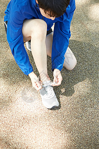 蹲下系鞋带的男青年图片素材