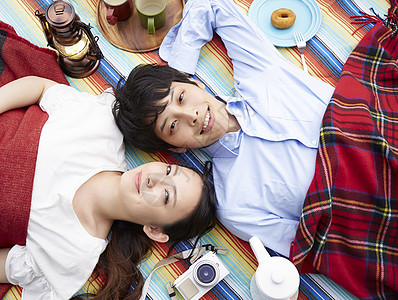 躺在野餐垫上开心的夫妇图片