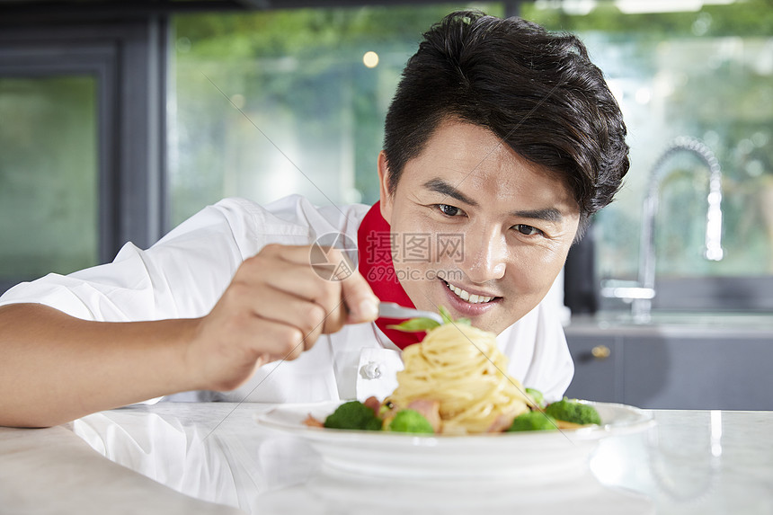 年轻男厨师制作菜品图片