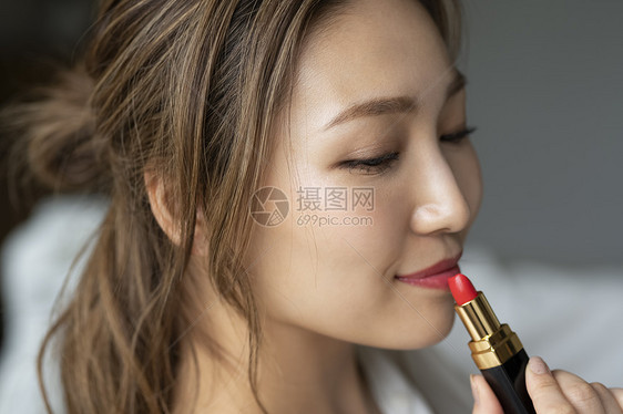 使用口红的年轻女子图片