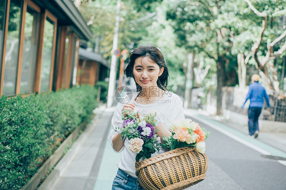 年轻美女捧着鲜花图片