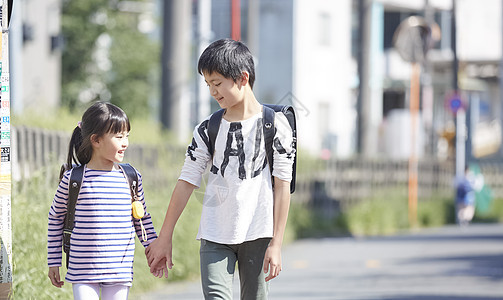 牵着妹妹一起上学的小男孩图片