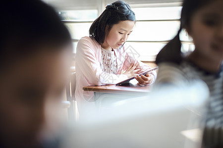 小学生在老师的指导下学习平板电脑使用知识图片