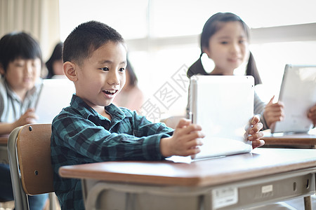 小学生在老师的指导下学习平板电脑使用知识图片