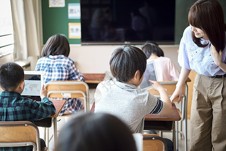 小学生在老师的指导下用电脑查询资料图片