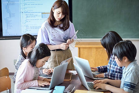 小学生在老师的指导下用电脑查询资料图片