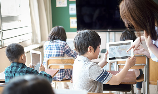 小学生在老师的指导下用电脑查询资料图片