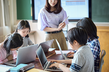 小学生在老师的指导下学习电脑使用知识图片