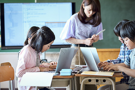 老师在教学生用电脑查询资料图片