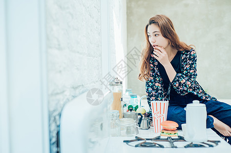 女人在室内吃零食图片