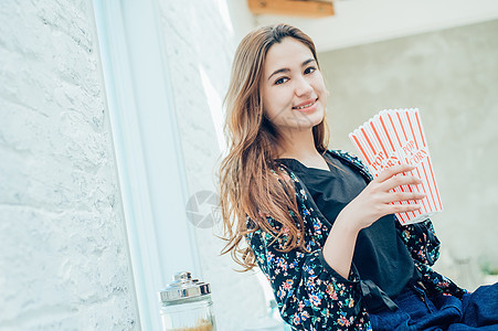 女人在室内吃零食图片