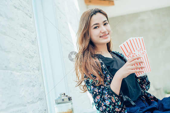 女人在室内吃零食图片