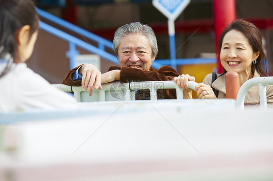 在游乐园里的老年夫妇带着孙女游玩图片