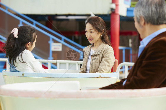 祖父母陪孙女在游乐园里游玩图片