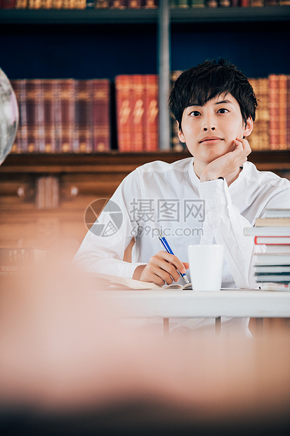 垂直构图一人亚洲人男子在图书馆写报告图片