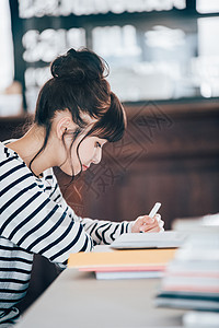 女小学生年轻女子学习在咖啡馆的妇女图片