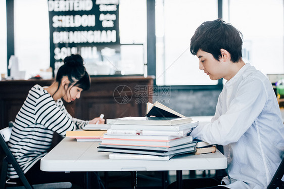 在一家咖啡馆学习的两名学生图片