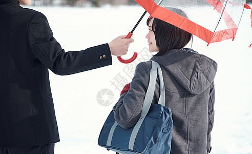 户外雪地男子给女生打伞图片