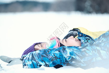 躺在雪地上的滑雪青年图片