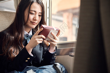 外套坐着日本人采取火车的高中女孩图片