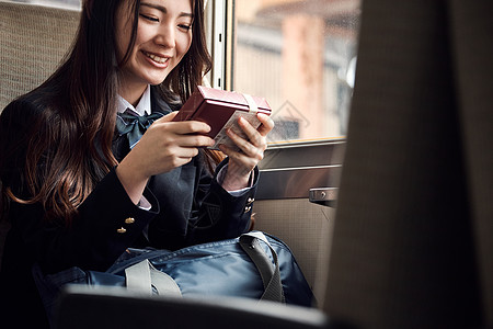 上学途中坐座位采取火车的高中女孩图片