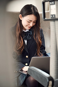 笔记本电脑一人便携电脑采取火车的高中女孩图片