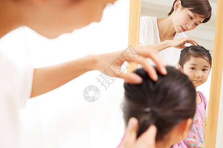 妈妈给小女儿整理头发背景图片