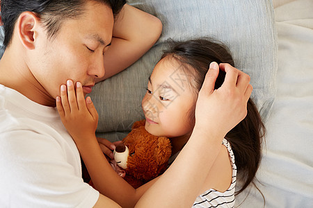 躺在床上休息的父亲和女儿图片