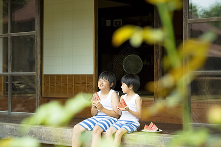 男孩抱着西瓜跑坐在老房子里的儿童背景