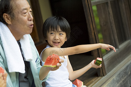 快乐男孩和爷爷在门口一起吃西瓜图片
