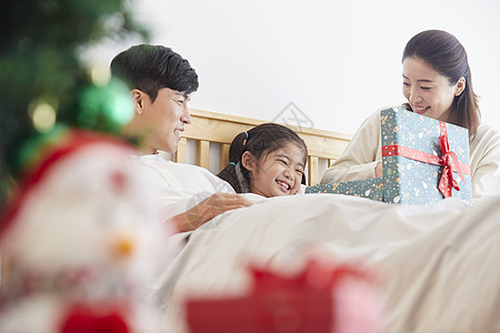 圣诞节幸福的一家人在床上休息图片